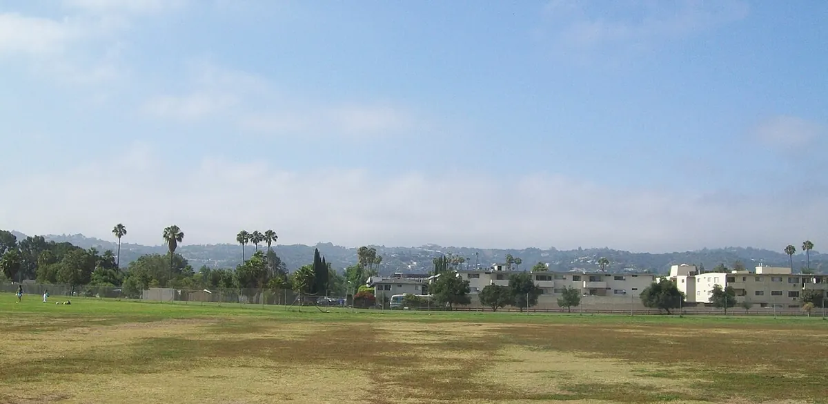 A green playing field and palm trees at Van Nuys Sherman Oaks Recreation Center in Los Angeles.